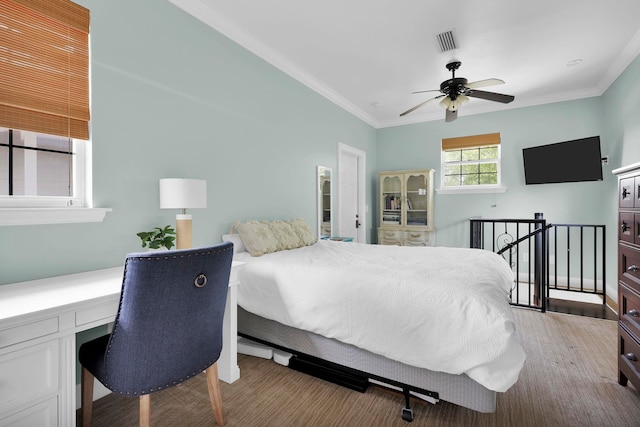 bedroom with visible vents, ceiling fan, crown molding, and built in desk