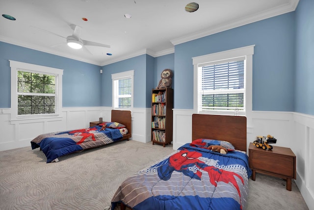 bedroom featuring crown molding, carpet, a wainscoted wall, and ceiling fan