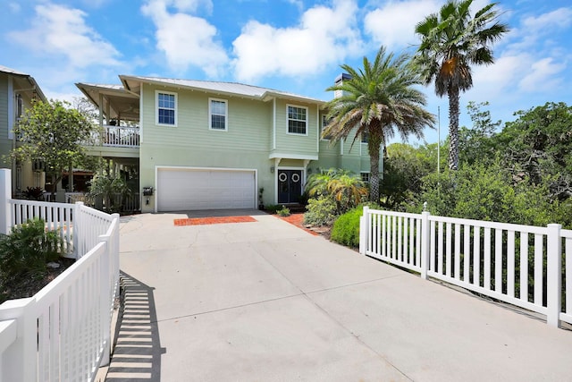 view of front of property with a balcony, fence, driveway, stucco siding, and a garage