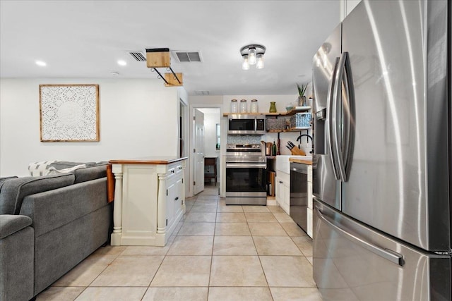 56 Dumas St, Saint Augustine, FL 32084 - kitchen with visible vents, appliances with stainless steel finishes, open shelves, open floor plan, and light tile patterned floors