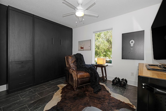 sitting room featuring a textured ceiling and ceiling fan