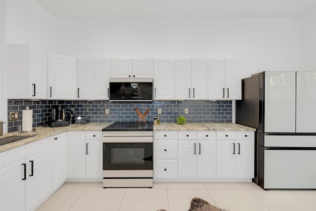 kitchen with white cabinetry, light tile patterned floors, white fridge, and electric range oven