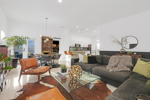 tiled living room with an inviting chandelier, sink, and a healthy amount of sunlight