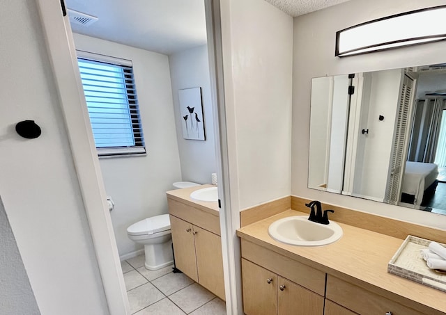 bathroom featuring vanity, tile patterned floors, and toilet