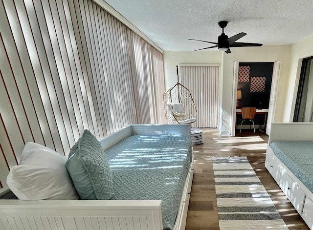 bedroom featuring ceiling fan, dark hardwood / wood-style floors, and a textured ceiling