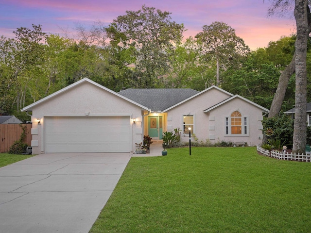 ranch-style home with stucco siding, a front lawn, driveway, and a garage