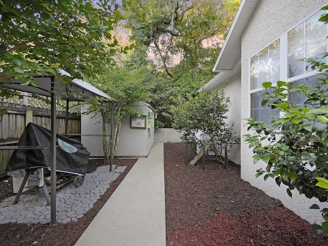view of yard featuring a fenced backyard, an outbuilding, a storage shed, and a patio