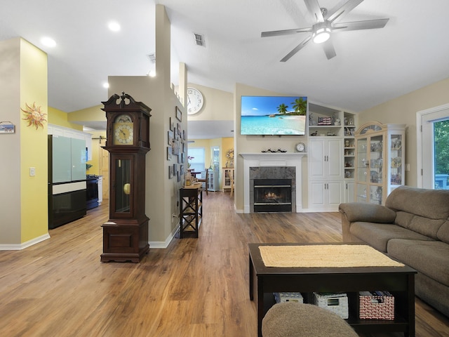 living area featuring lofted ceiling, visible vents, a ceiling fan, and light wood-type flooring