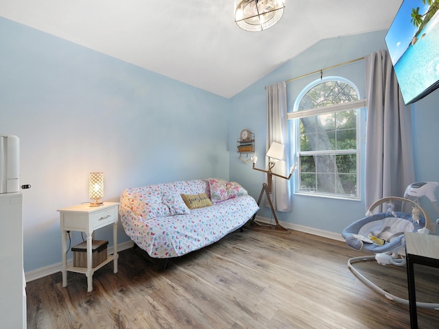 sitting room featuring baseboards, vaulted ceiling, and wood finished floors