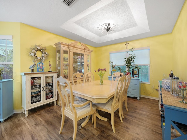 dining space featuring baseboards, visible vents, wood finished floors, beverage cooler, and a raised ceiling