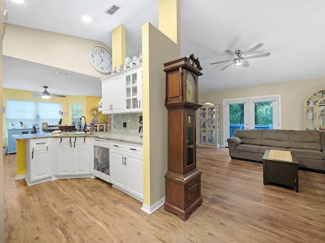 kitchen with ceiling fan, a peninsula, open floor plan, and visible vents