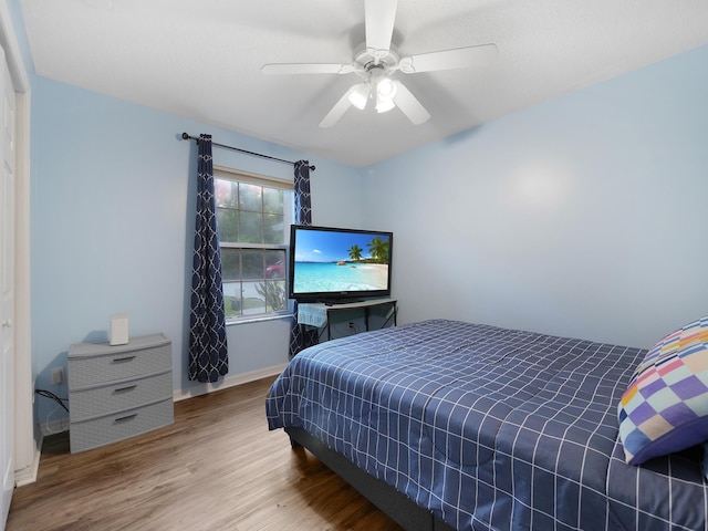 bedroom with baseboards, a ceiling fan, and wood finished floors
