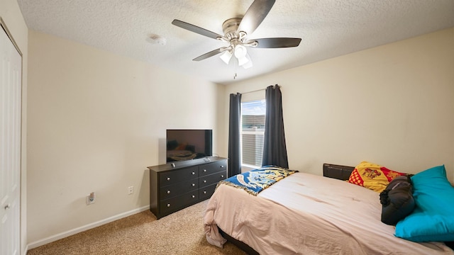 bedroom featuring baseboards, a ceiling fan, a textured ceiling, carpet flooring, and a closet