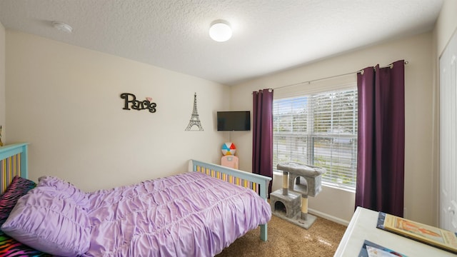 bedroom with carpet, baseboards, and a textured ceiling