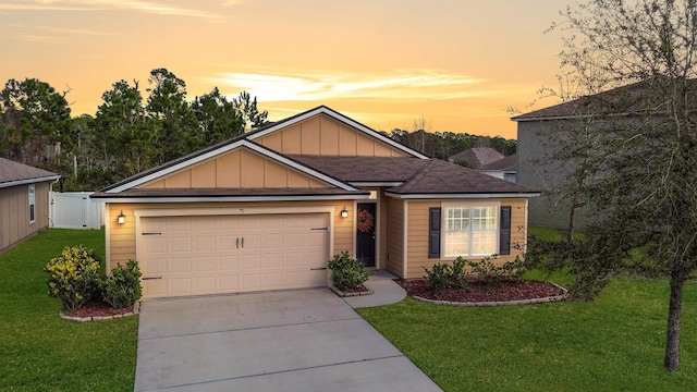 ranch-style house featuring an attached garage, concrete driveway, board and batten siding, and a front yard