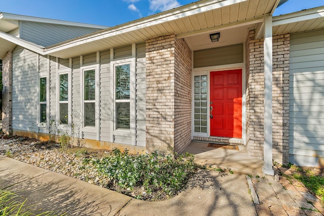 view of exterior entry featuring brick siding