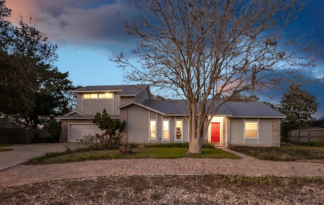 view of front of house featuring a garage, driveway, and fence