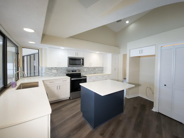 kitchen featuring appliances with stainless steel finishes, sink, a center island, dark hardwood / wood-style floors, and white cabinetry