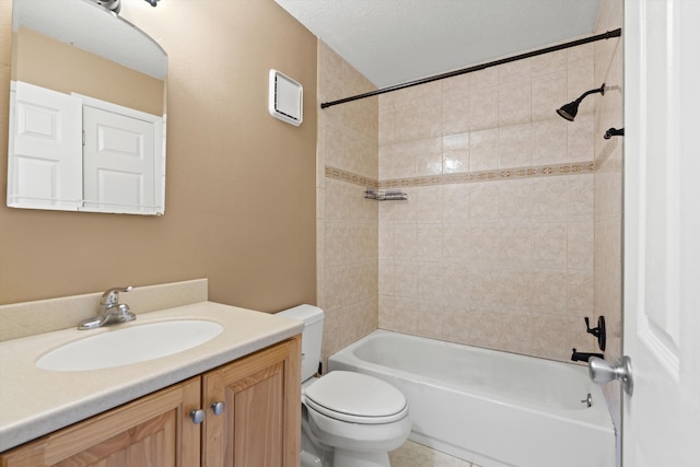 full bathroom with a textured ceiling, vanity, toilet, and tiled shower / bath