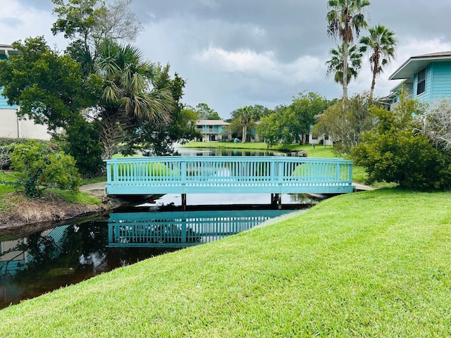 exterior space with a lawn and a deck with water view