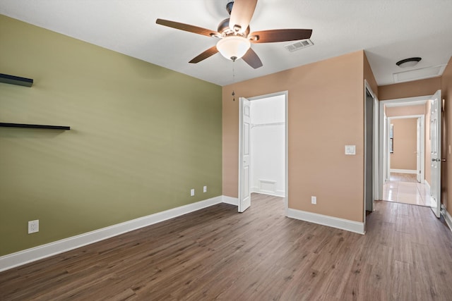 unfurnished bedroom with ceiling fan, wood-type flooring, and a closet