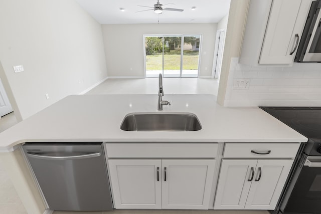 kitchen featuring sink, tasteful backsplash, white cabinetry, ceiling fan, and stainless steel appliances