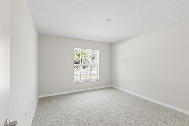 spare room featuring carpet floors and a textured ceiling