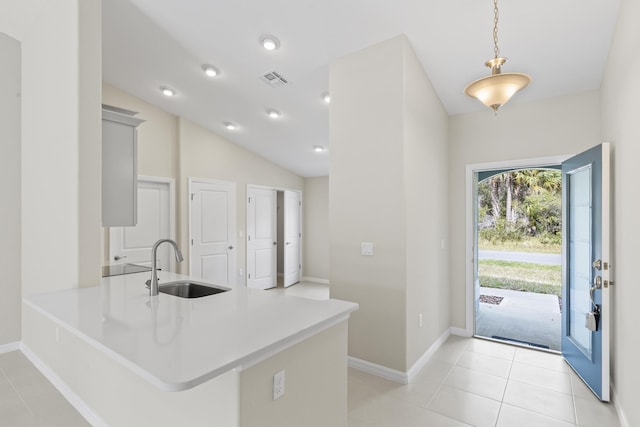 kitchen with sink, light tile patterned flooring, decorative light fixtures, vaulted ceiling, and kitchen peninsula