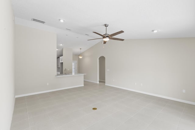 empty room with lofted ceiling, sink, light tile patterned floors, and ceiling fan