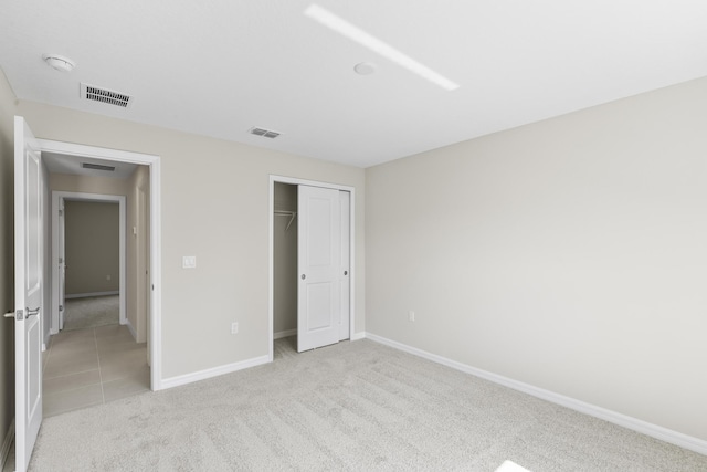 unfurnished bedroom featuring light colored carpet and a closet