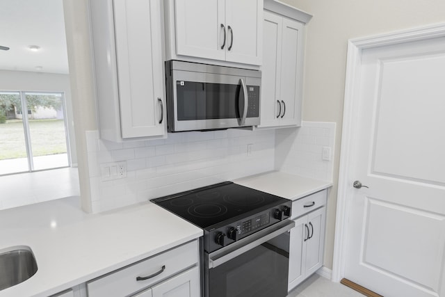 kitchen with white cabinetry, black electric range oven, and decorative backsplash