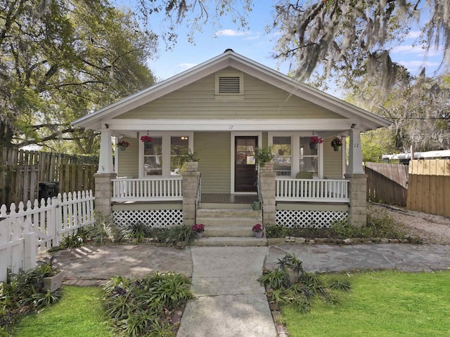 bungalow featuring fence and covered porch