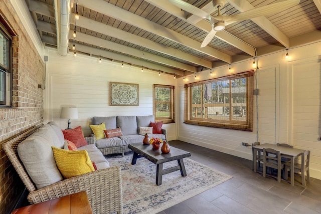 sunroom / solarium featuring beamed ceiling, ceiling fan, and wooden ceiling