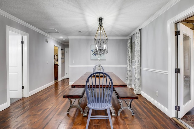 dining room with a textured ceiling, dark hardwood / wood-style floors, crown molding, and an inviting chandelier