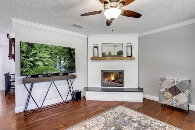 living room with dark wood-type flooring, a textured ceiling, and ornamental molding