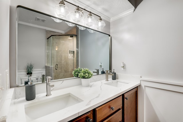 bathroom featuring a textured ceiling, vanity, an enclosed shower, and ornamental molding