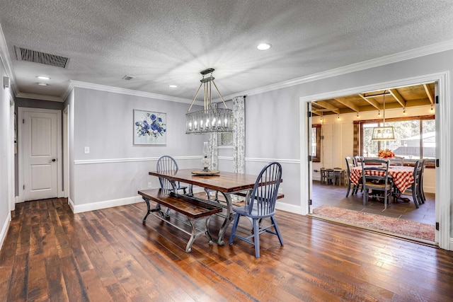 dining area with a textured ceiling, dark hardwood / wood-style floors, and ornamental molding