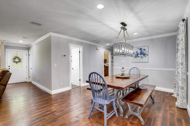 dining space with dark hardwood / wood-style flooring, a chandelier, a textured ceiling, and ornamental molding