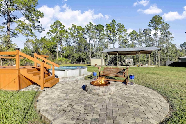 view of patio / terrace featuring a gazebo, a storage unit, and an outdoor fire pit