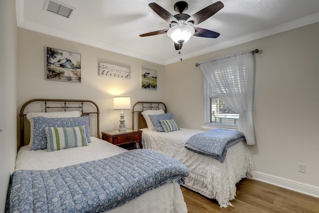 bedroom with ceiling fan, dark hardwood / wood-style flooring, ornamental molding, and a textured ceiling