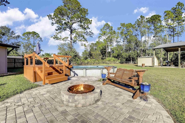 view of patio featuring a fire pit and a storage unit