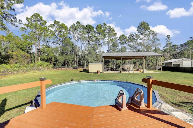 view of pool featuring a gazebo, a yard, a shed, and a wooden deck