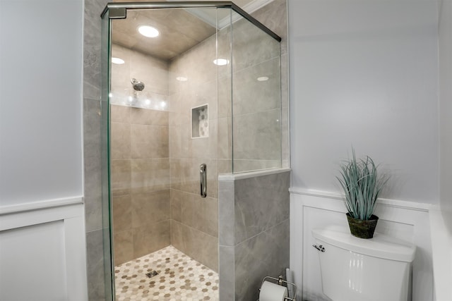 bathroom with toilet and a shower with shower door