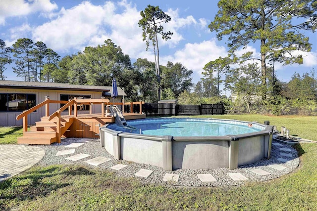 view of swimming pool with a yard and a wooden deck