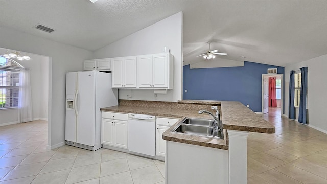 kitchen featuring a sink, white appliances, a peninsula, lofted ceiling, and light tile patterned flooring