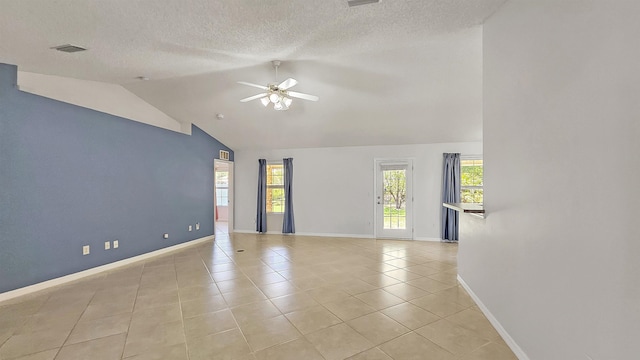 spare room with ceiling fan, baseboards, light tile patterned floors, healthy amount of natural light, and vaulted ceiling