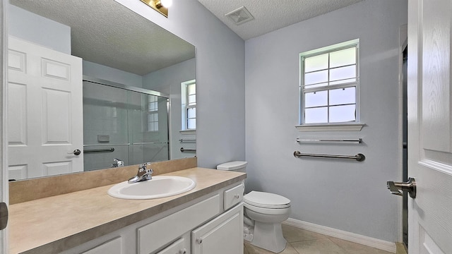 bathroom with a shower stall, tile patterned flooring, a textured ceiling, toilet, and vanity