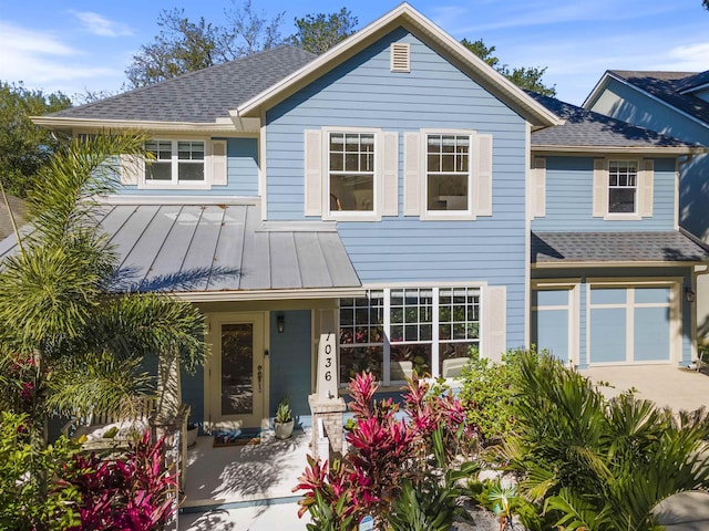 1036 Saltwater Cir, Saint Augustine, FL 32080 - view of front facade with a shingled roof, a standing seam roof, driveway, a garage, and covered porch