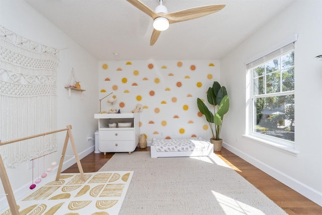 1036 Saltwater Cir, Saint Augustine, FL 32080 - bedroom with wallpapered walls, wood finished floors, a ceiling fan, and an accent wall