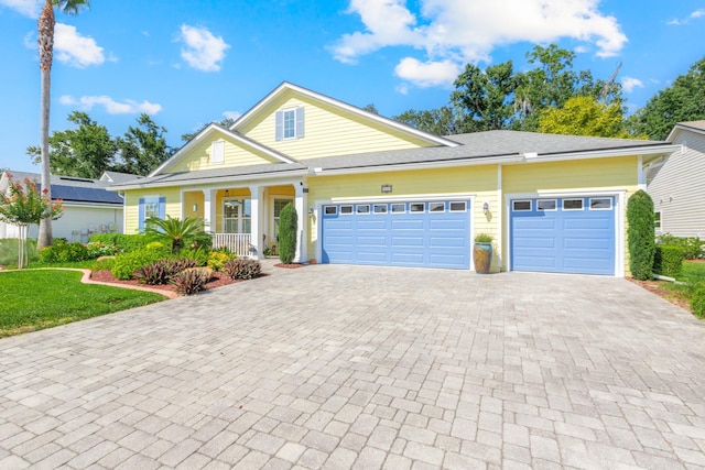 view of front of property with a front yard, a porch, and a garage